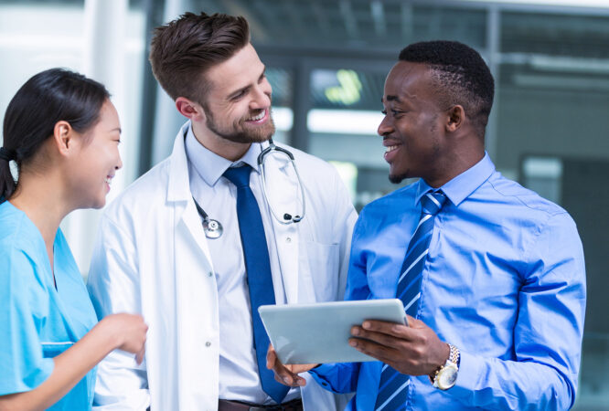 Nurse and doctor having a discussion with businessman in hospital