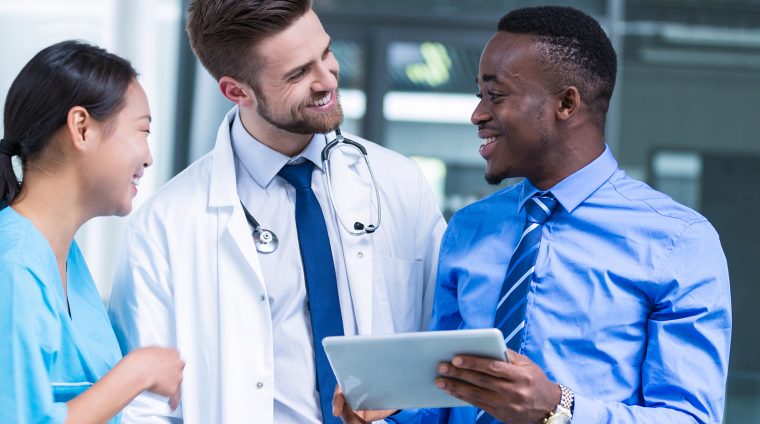 Nurse and doctor having a discussion with businessman in hospital